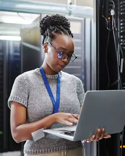 Ingénieure H DATA Solutions travaillant sur un ordinateur portable dans un datacenter